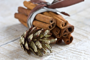Group of spaces with cinnamon and pine cone on wooden table