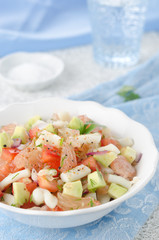 A bowl of salad with squid, avocado and grapefruit