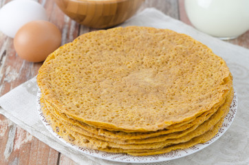 Stack of crepes made ​​of corn flour on a plate and baking i