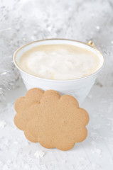 ginger biscuits, cup of cappuccino, Christmas tinsel on a white