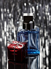 Perfume with red gift box over abstract background. Low key.