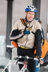 Naklejka premium Male Cyclist With Courier Bag Using Walkie-Talkie