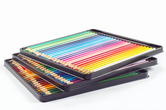 Three sets of color pencils in pencil case on a white background