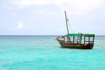 Fototapeta na wymiar Drewniana łód¼ unosi się na turkusowe morze