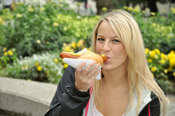 Junge Frau isst Bratwurst