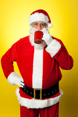 Fototapeta na wymiar Portrait of a aged Santa sipping coffee