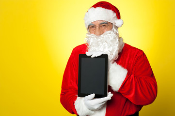 Fototapeta na wymiar Santa Claus gospodarstwa nowo uruchomionej urządzenie tablet