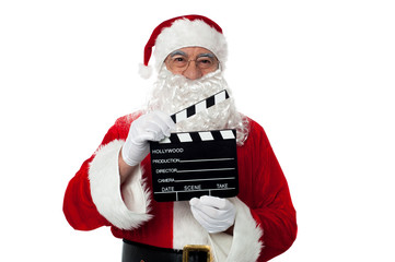 Cheerful aged Santa posing with a clapperboard