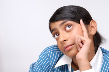 Portrait of happy young Indian girl thinking