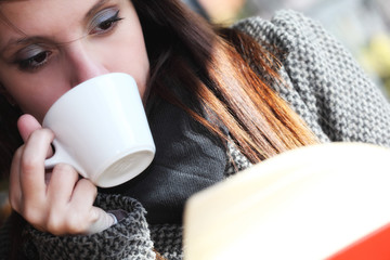 Ragazza con libro e caffè