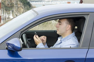Conductor mira el telefono.