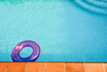 Fototapeta na wymiar Purple tube in a turquoise swimming pool