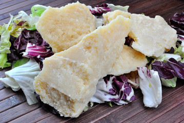 Pezzi di parmigiano su foglie di insalata