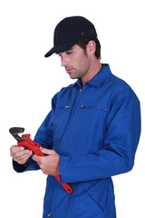 Tradesman adjusting a pipe wrench