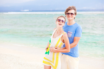 young happy couple having fun on tropical beach. honeymoon