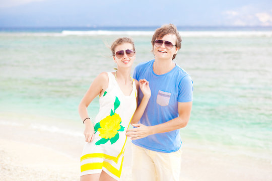 young happy couple having fun on tropical beach. honeymoon