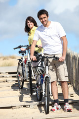 Couple cycling by the beach