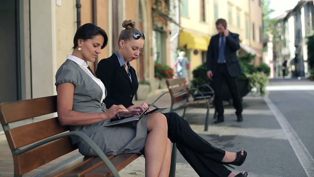 Businesswomen finishing work on laptop and relaxing in the city