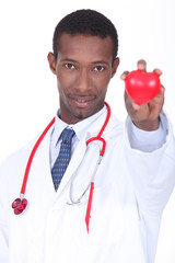 Hospital doctor with a plastic heart in the palm of his hand