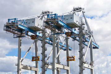 Heavy cranes against cloudy sky