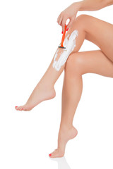 Woman shaving her legs, white background