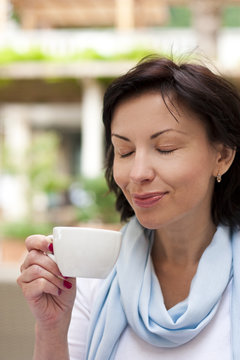 Young woman drinking espresso on the street