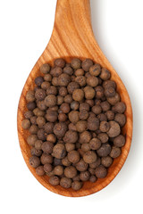 whole allspice berries in a wooden spoon