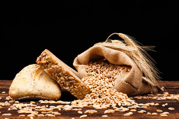 assortment of baked bread on wood table and black background