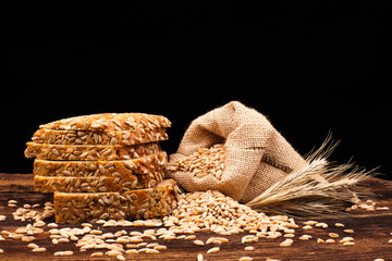 assortment of baked bread on wood table and black background