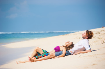 Fototapeta premium loving couple resting on the beach in the sand on the island of Bali.