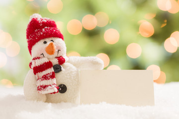 Cute Snowman with Blank White Card Over Abstract Background