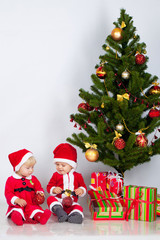 Two children under christmas pine
