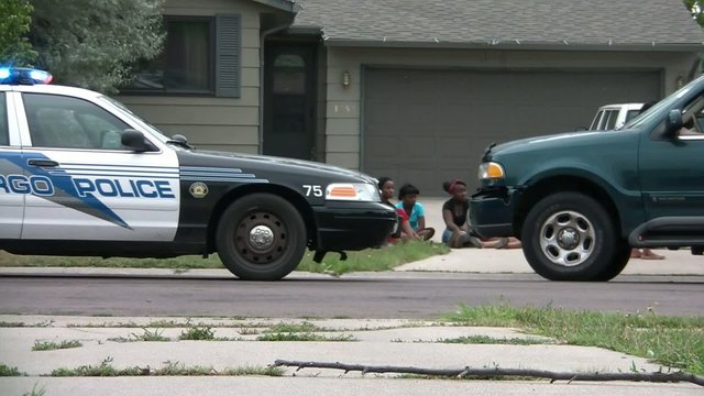 Girls Sit Next to Police Car During Investigation