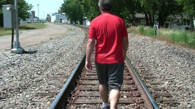 Man Walking Down Railroad Tracks