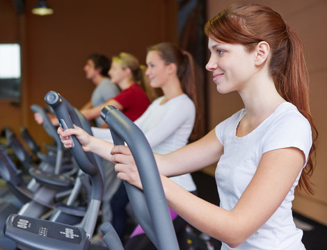Frau am Crosstrainer im Fitnesscenter