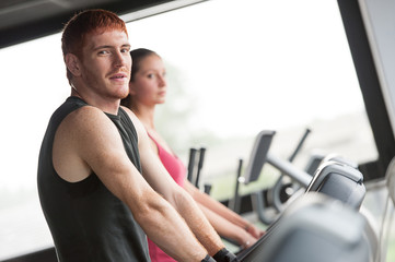 Fototapeta premium Running on treadmill in gym or fitness club - group of women and