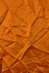 Orange fabric texture with creases.