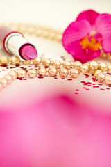 Obraz na płótnie Canvas pink lipstick with golden beaded necklace