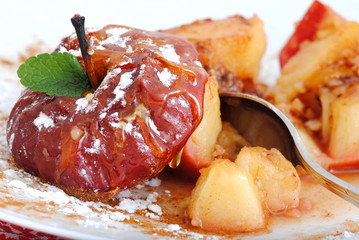 baked apples with cinnamon, honey, raisins in white plate