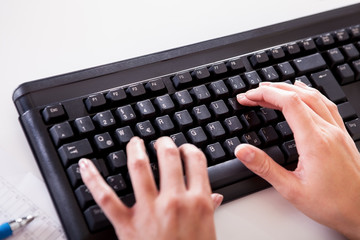 Female hands typing on a laptop keyboard