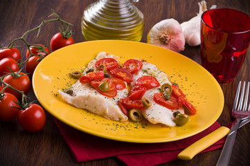 Fish with cherry tomatoes and olive.