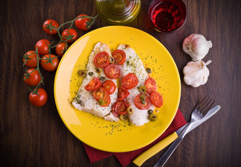 Fish with cherry tomatoes and olive.
