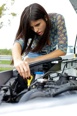 Woman checking car broken engine