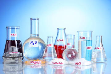 Test-tubes with various acids and chemicals on blue background