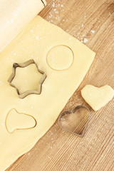 tin of cookies on the rolled out dough on wooden table close-up
