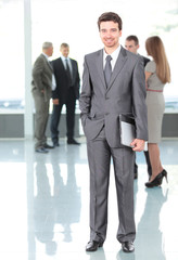 Fototapeta premium Happy smart business man with team in the background