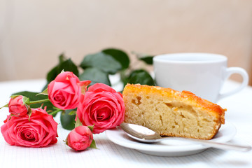 Obraz na płótnie Canvas A home-made cake with a cup of tea and flower