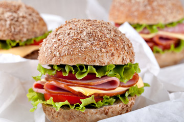 Sandwich with bacon and vegetables on wooden table