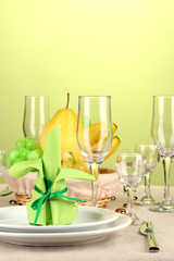 Table setting in green and yellow tones on color  background