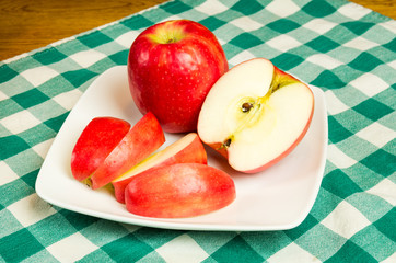 Naklejka na ściany i meble Pink Lady apple slices on a white plate